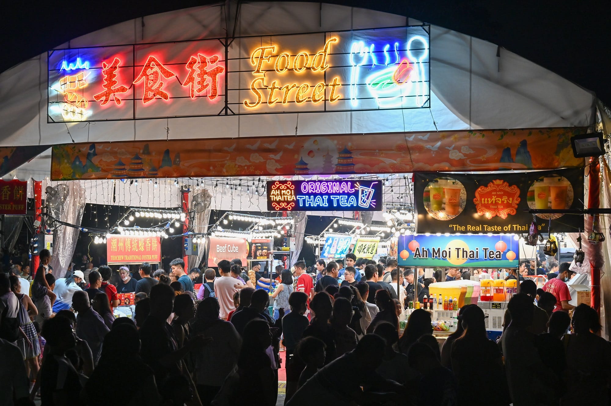eventgoers entering a brightly lit food street
